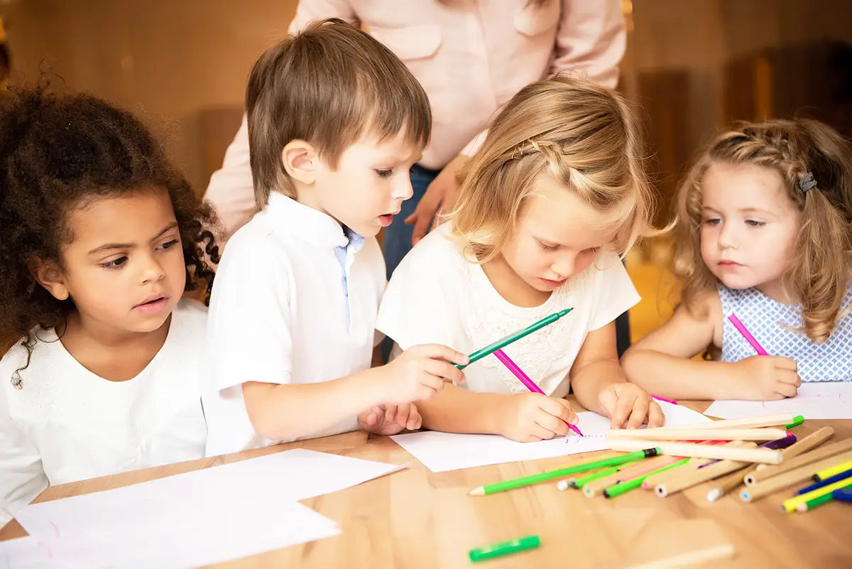 Kinder malen gemeinsam am Tisch